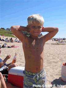 A child poses for a photo at the beach.